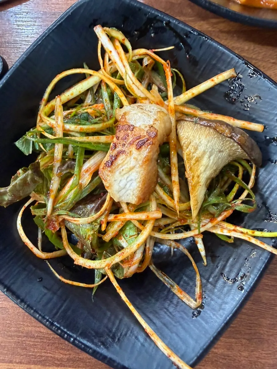 Grilled mushrooms served with shredded scallions