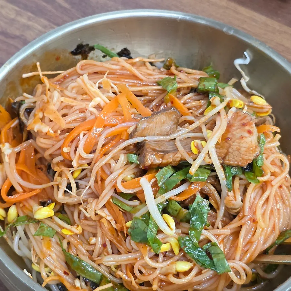 Spicy mixed pork noodles topped with vegetables and pork