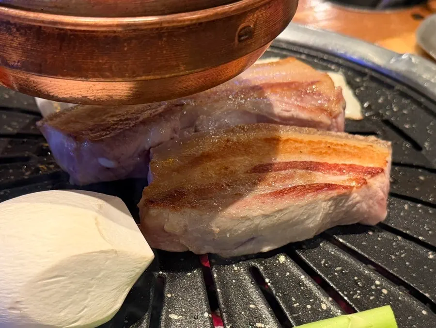 Black pork belly grilling on the tabletop grill