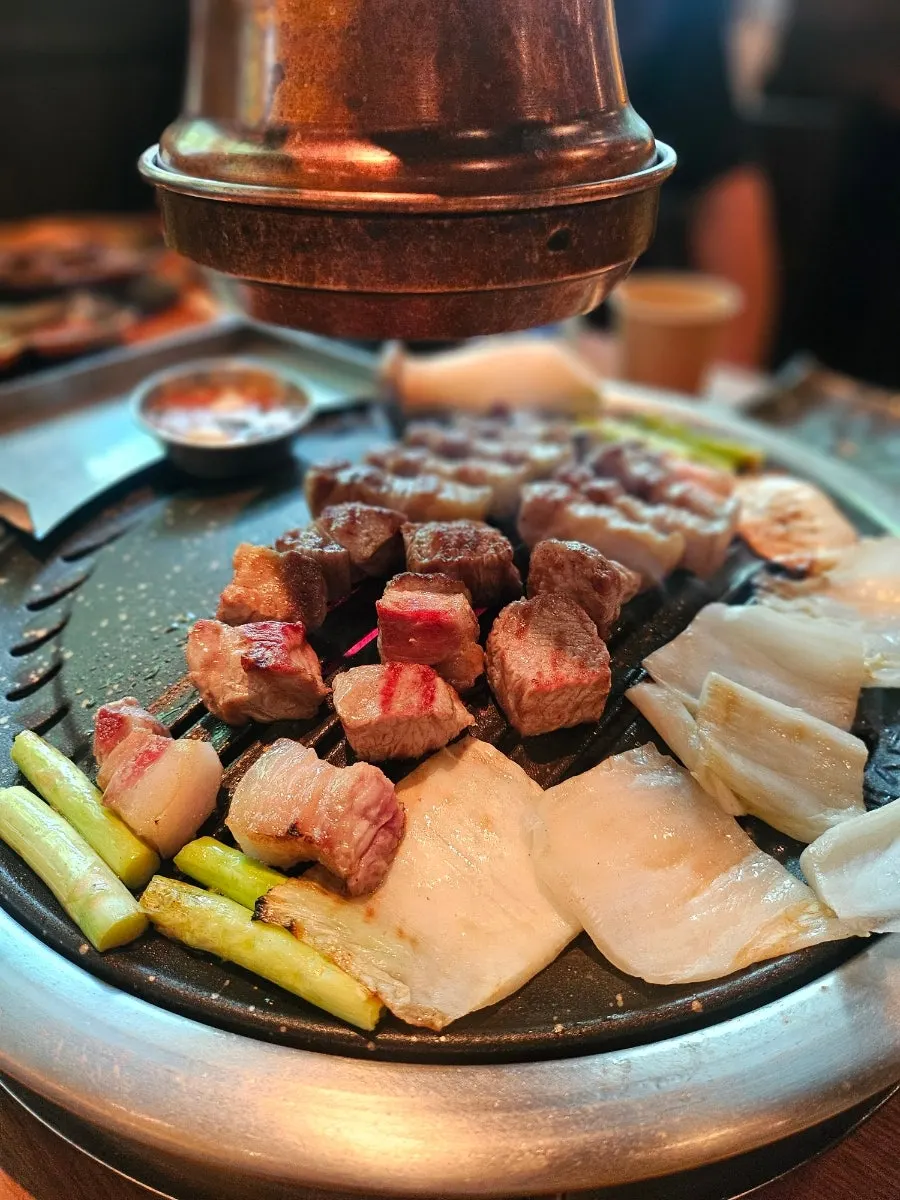 불판에서 노릇하게 익어가는 두툼한 흑돼지