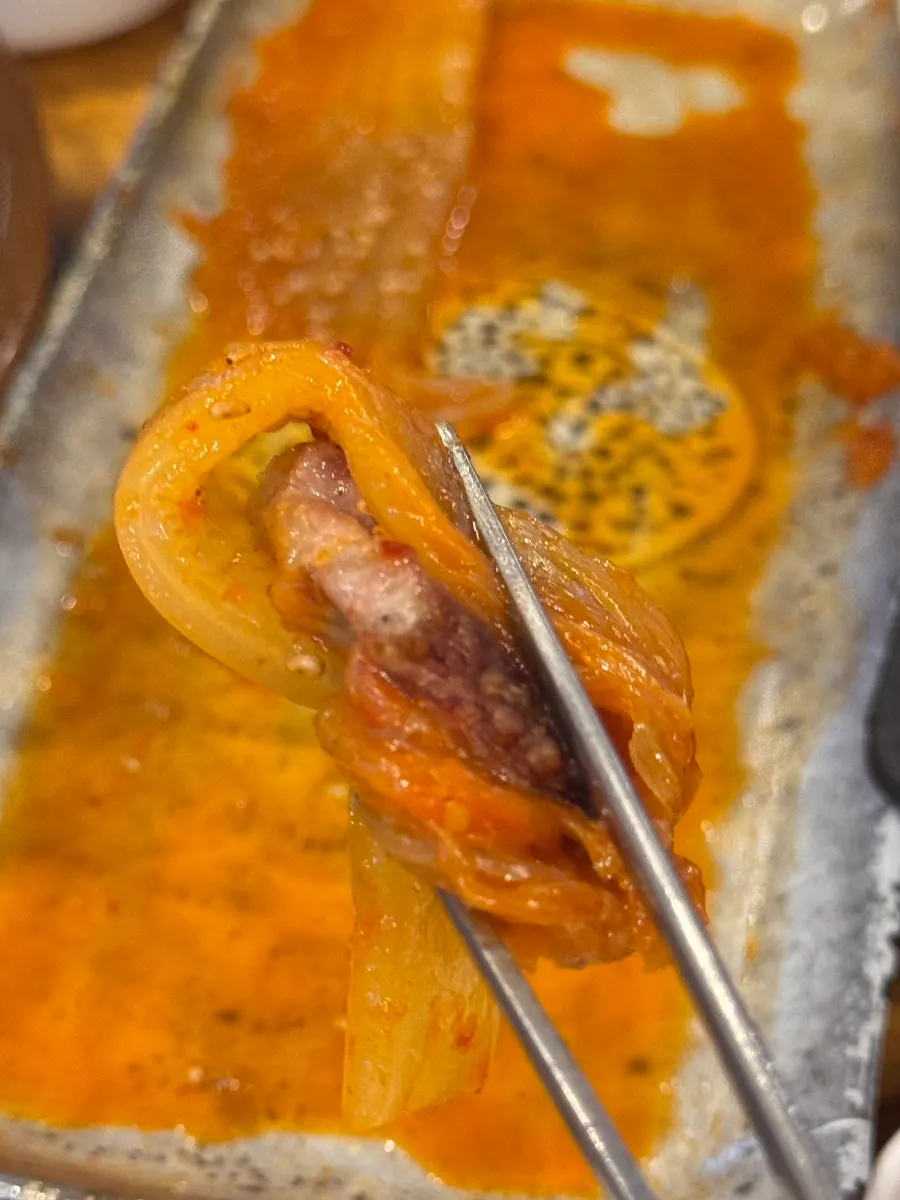 Meat and shredded scallion on a lettuce leaf
