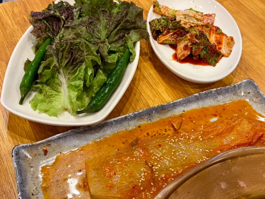 Plates of salad and geotjeori side dishes