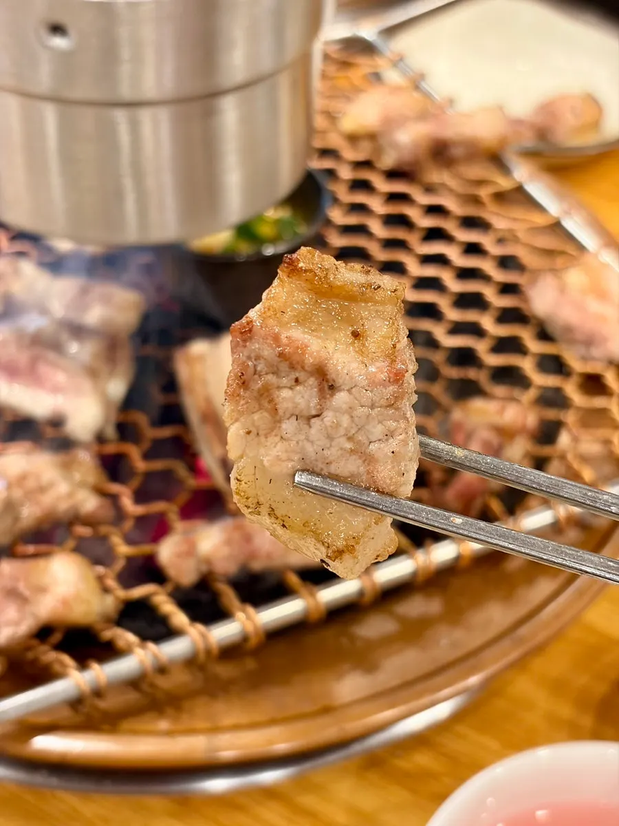 Bone-in fresh ribs grilling over charcoal