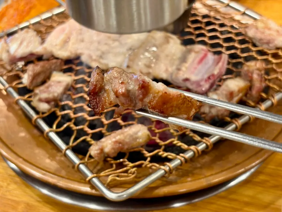 Black pork samgyeopsal grilling on the grill
