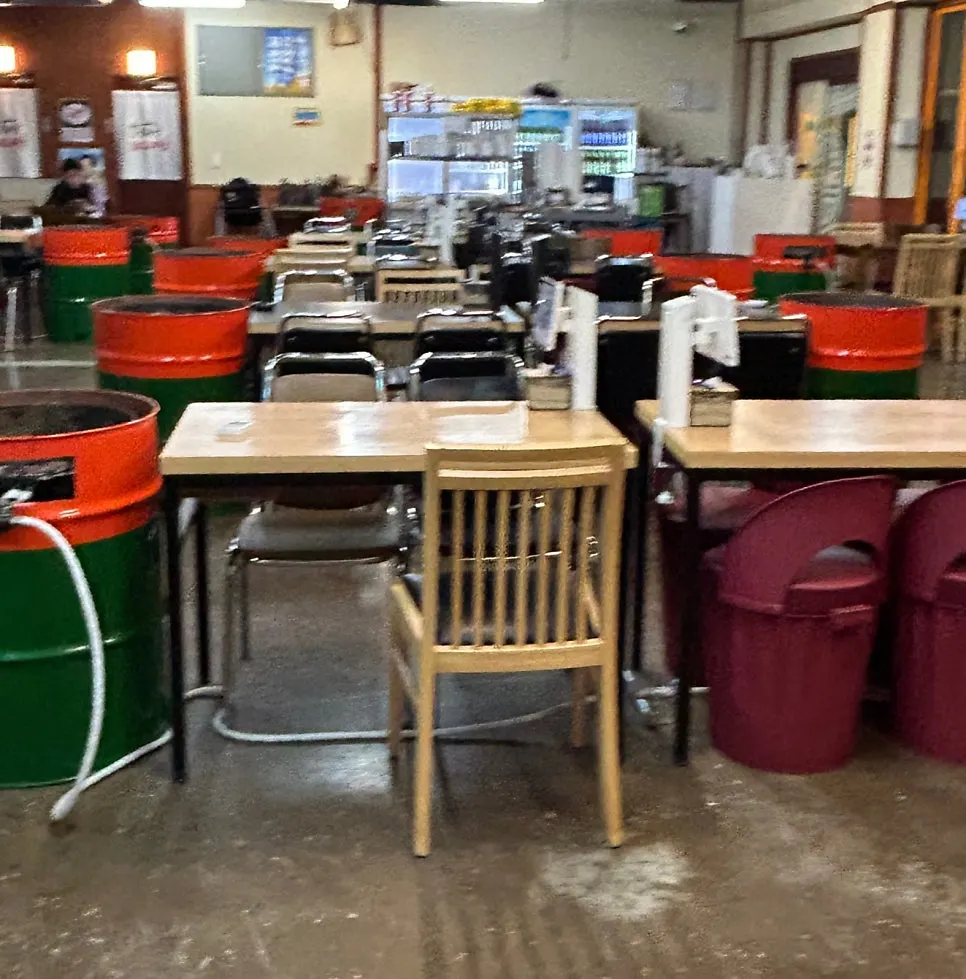 Restaurant interior with lid pots set on drums at each table