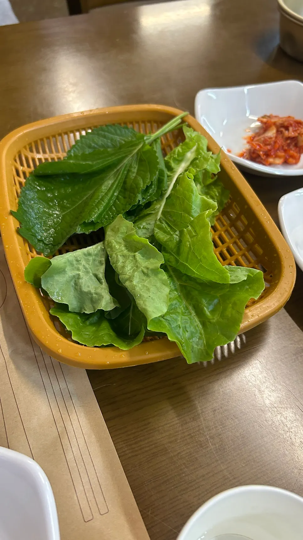 A plate of leafy wrap greens including perilla leaves
