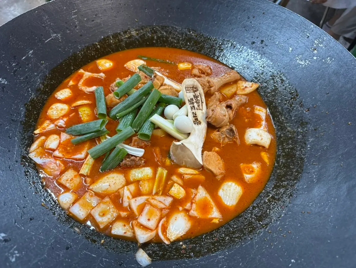Cauldron-lid dakdoritang piled high with chicken, potatoes, onion and green onion