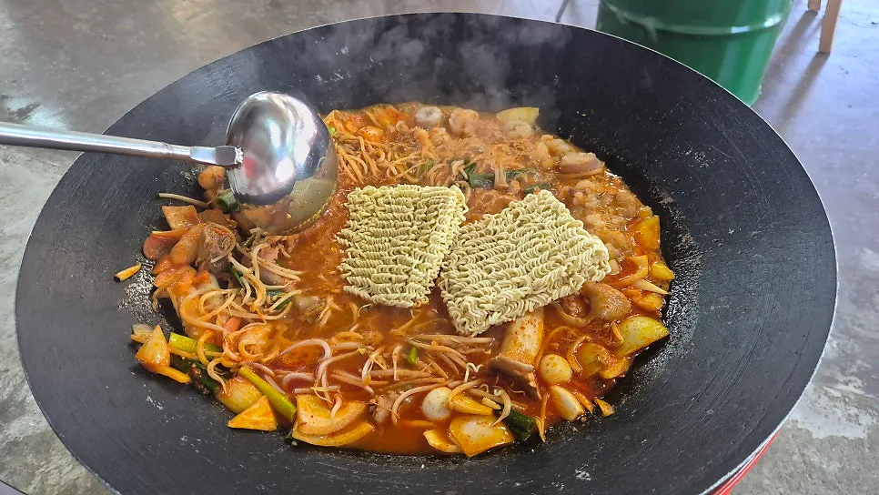 Beef tripe dakdoritang cooking on a pot lid
