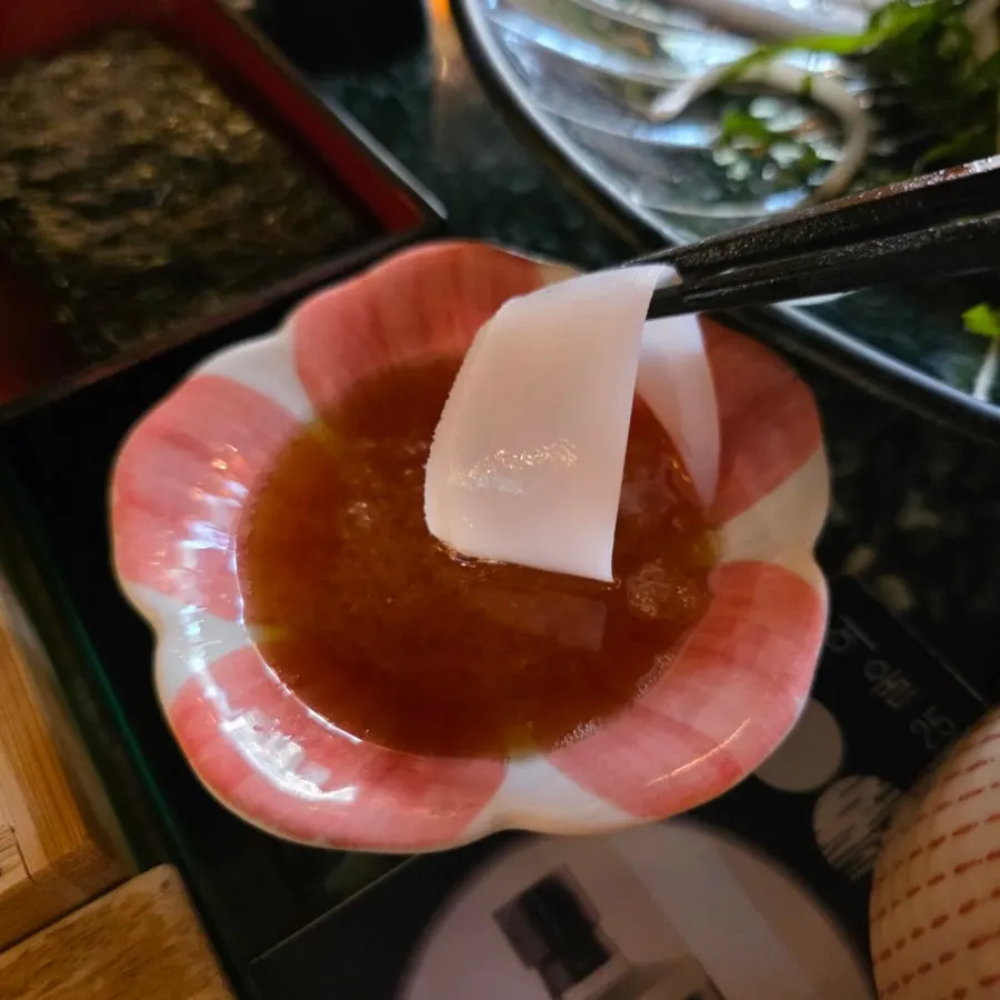 먹물소금에 찍은 무늬오징어 회 한 점