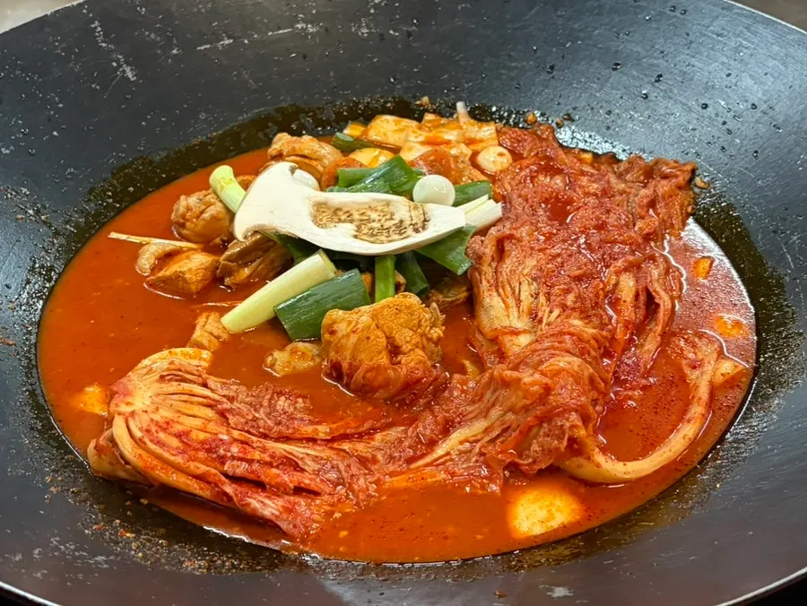 닭고기와 묵은지, 떡과 감자가 올려진 솥뚜껑 구성