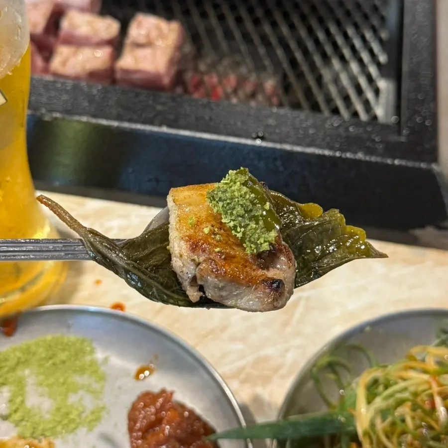 A recommended combo bite of black pork with chili pepper on top
