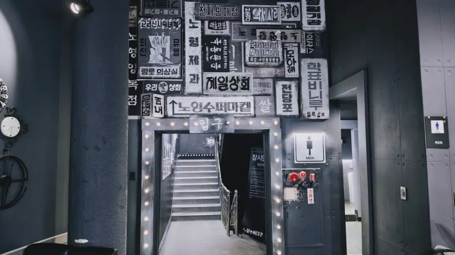 Corridor leading to the exhibition hall lined with old signs and posters