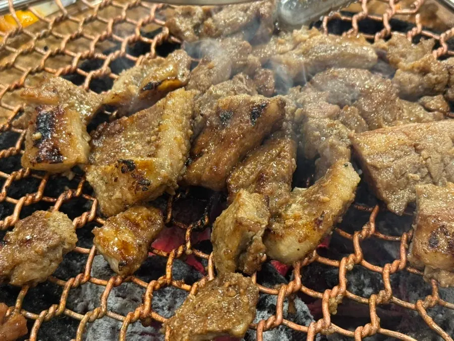 숯불 불판 위 고기 굽는 장면