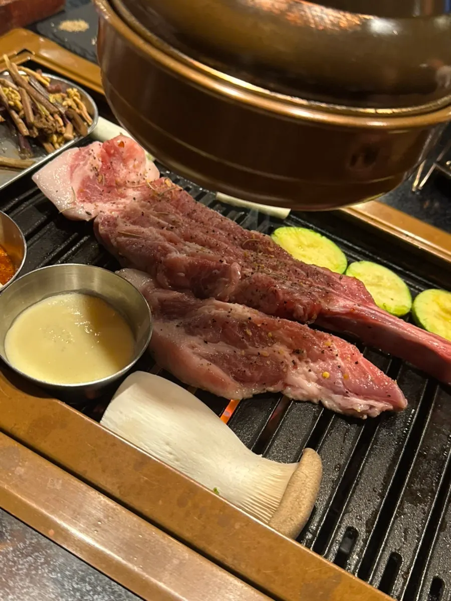Black pork shoulder rack grilling on the barbecue