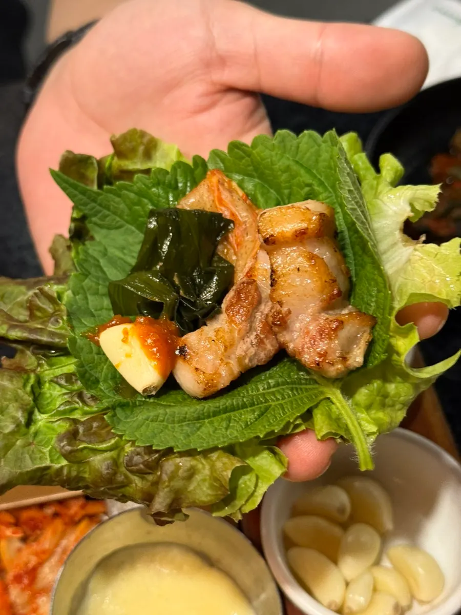 A piece of black pork served with bracken fern