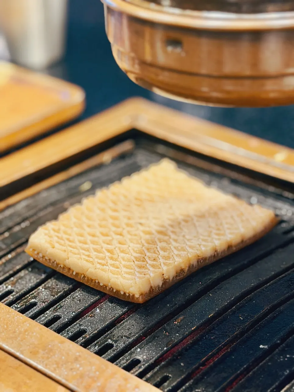 Scored black pork skin being grilled