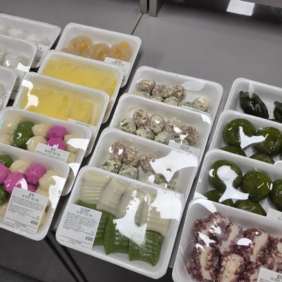 Various rice cakes on display including injeolmi and songpyeon