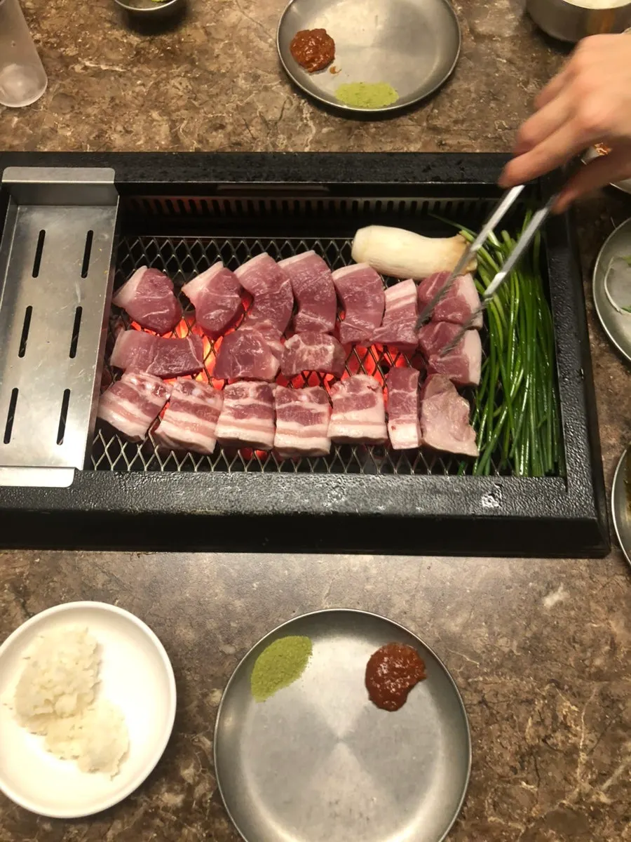 Thick-cut meat cooking on the charcoal grill