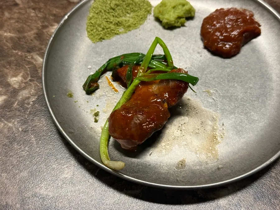 A piece of black pork with mel jeot and chives