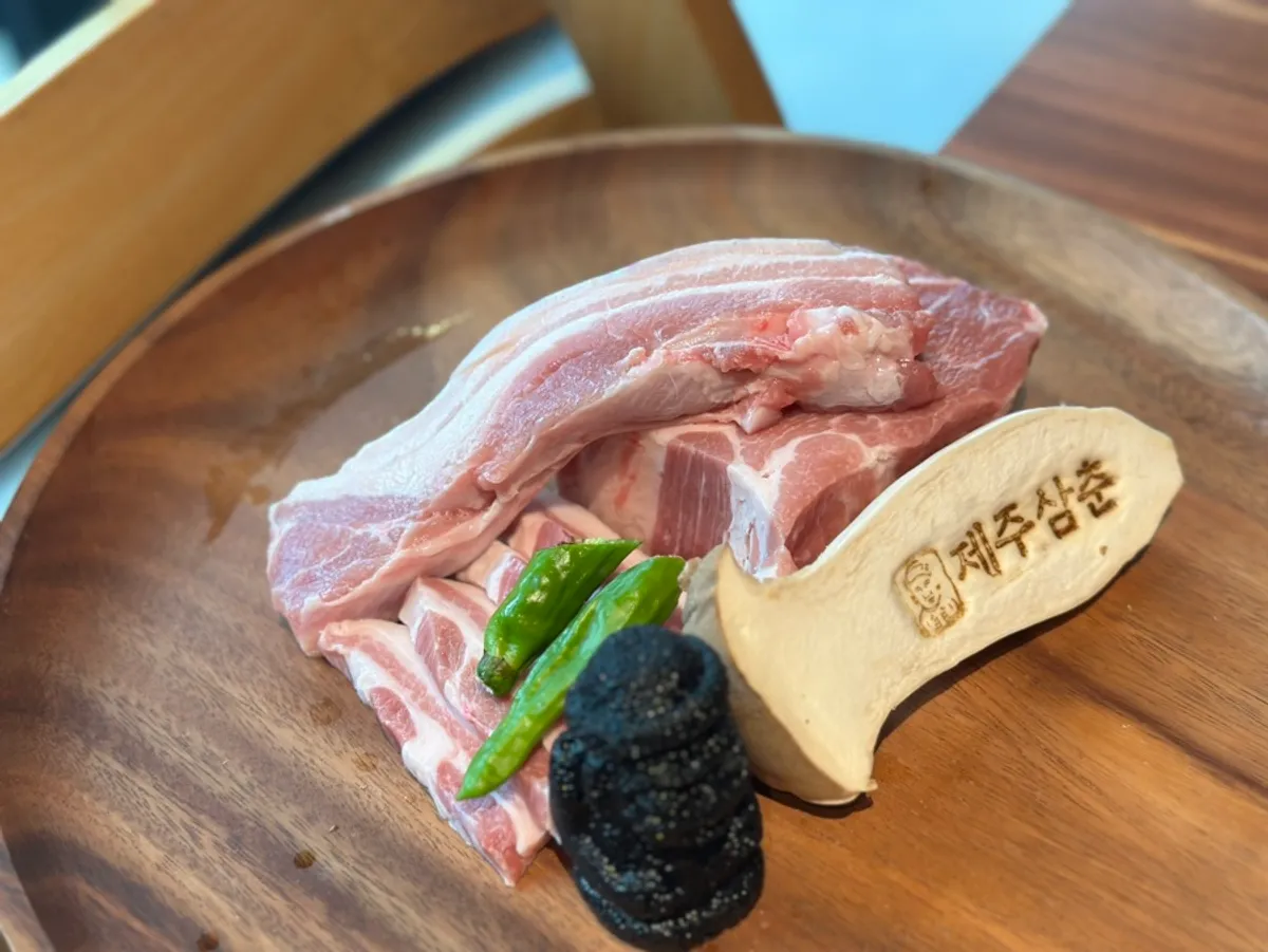 Aged black pork served with a dol hareubang statue