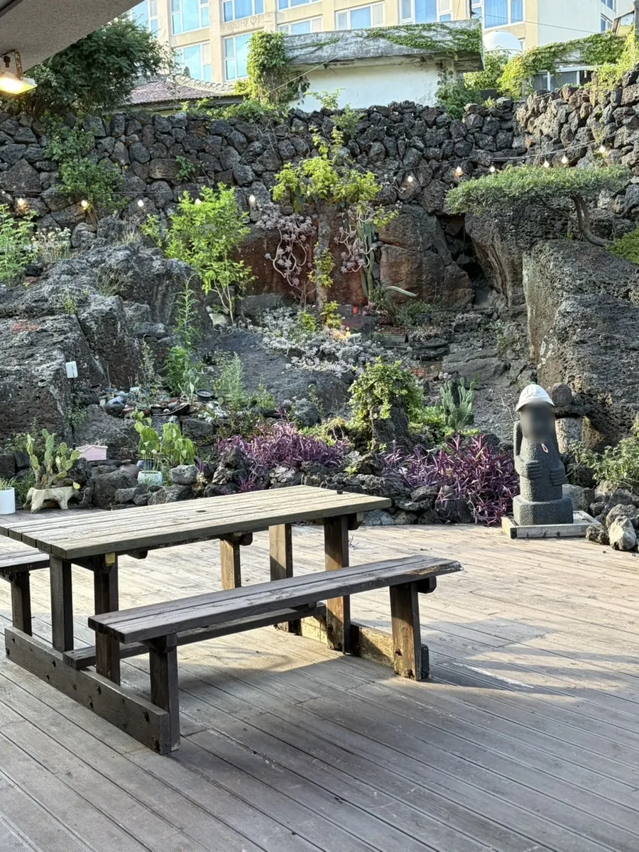 Jeju Samchun's outdoor garden view with stone wall through open windows