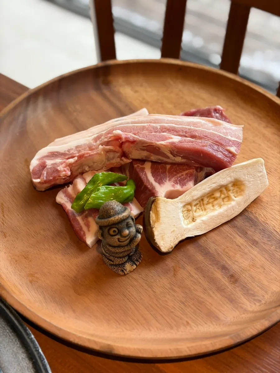 Tableside performance showing black pork smoked over grapevine chips