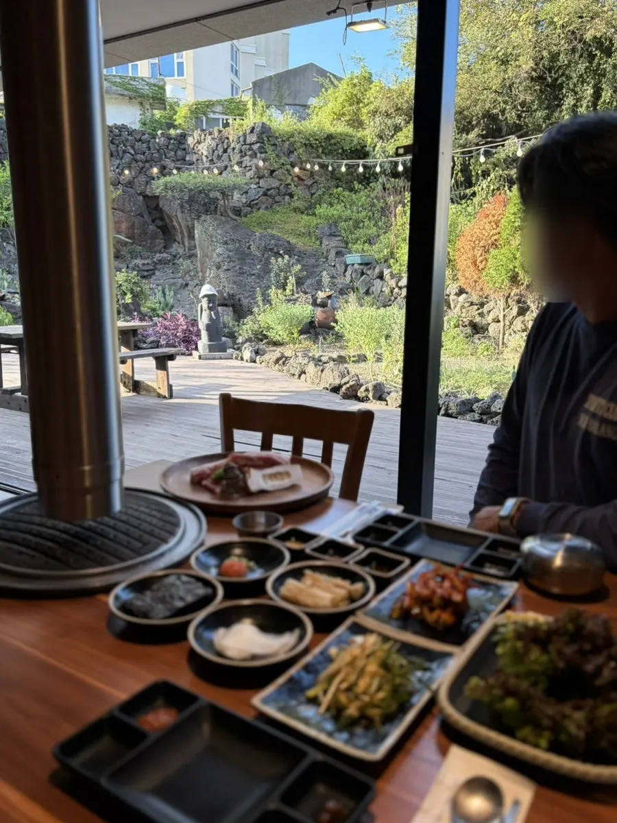 Black pork grilling with the garden in the background