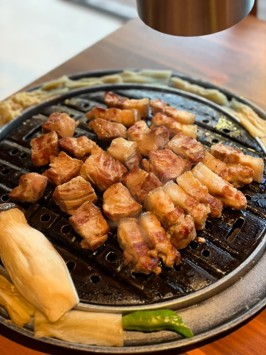 Neck and belly cuts arranged neatly beside the grill