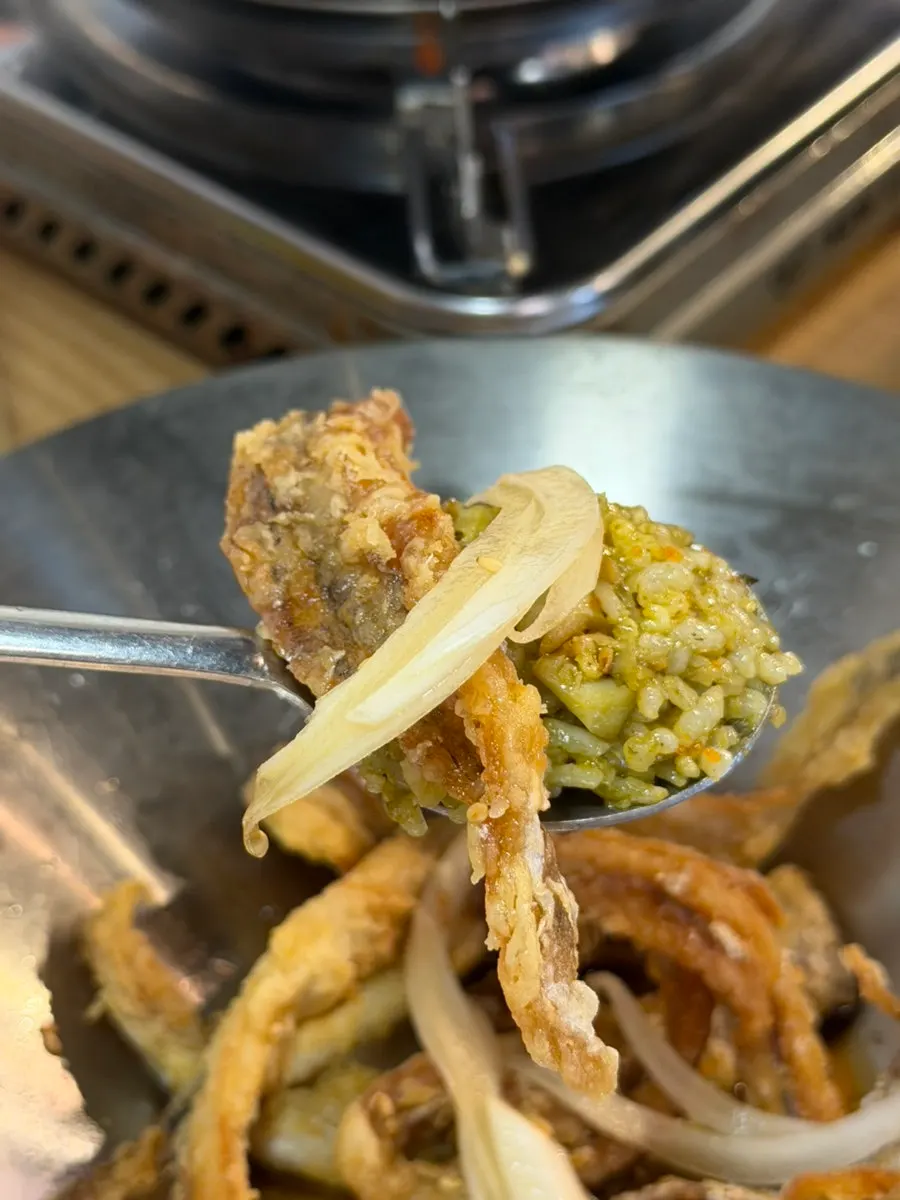 A spoonful of roe rice topped with fried cutlassfish