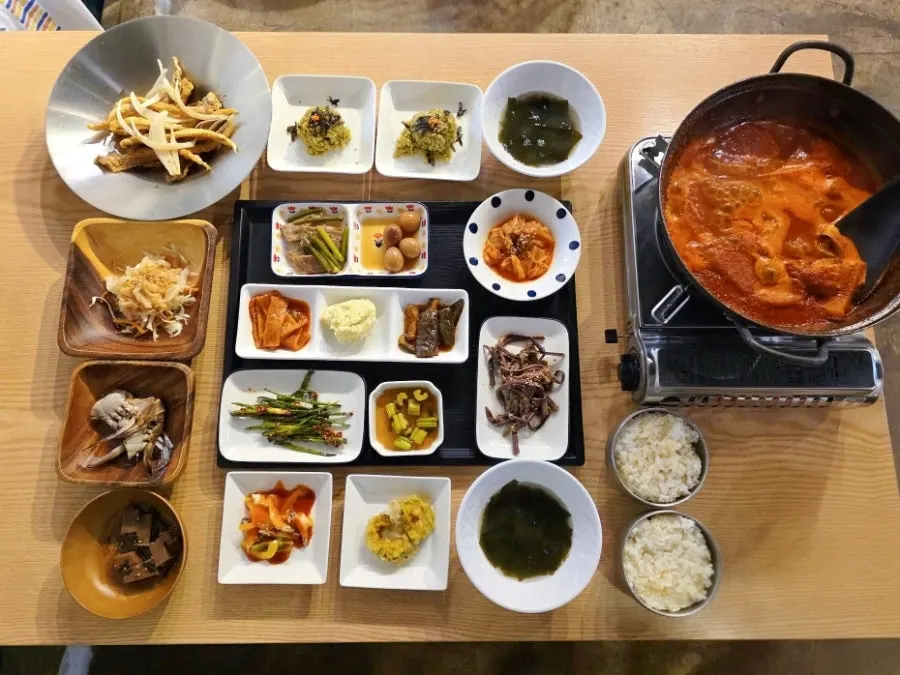 Spread of side dishes including seaweed soup and soy-marinated crab
