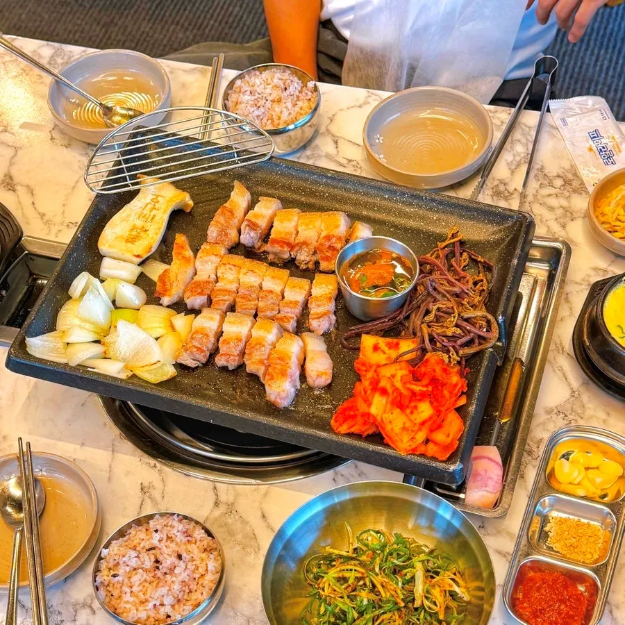 불판 위에서 구워지는 흑오겹살과 버섯