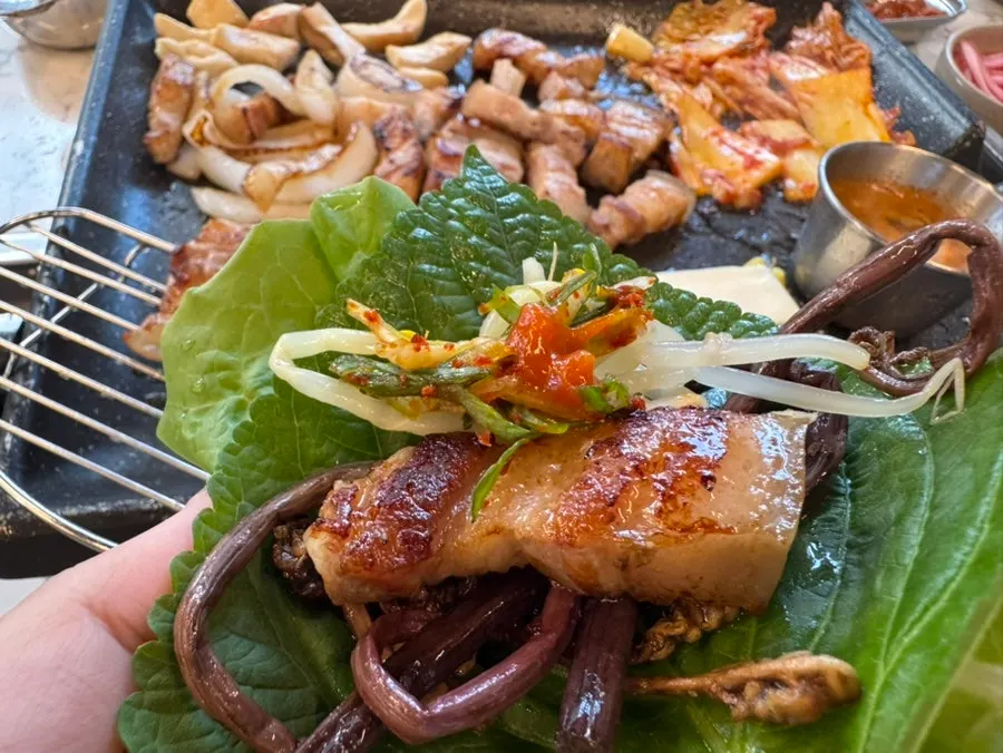 Black pork belly wrapped in leafy greens