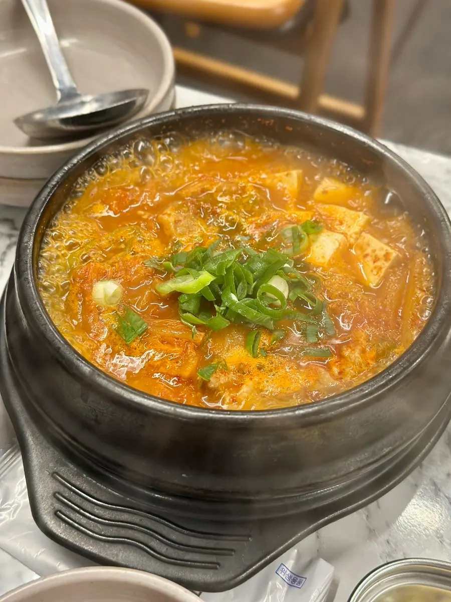 불판 가장자리에서 구워지는 고사리와 김치