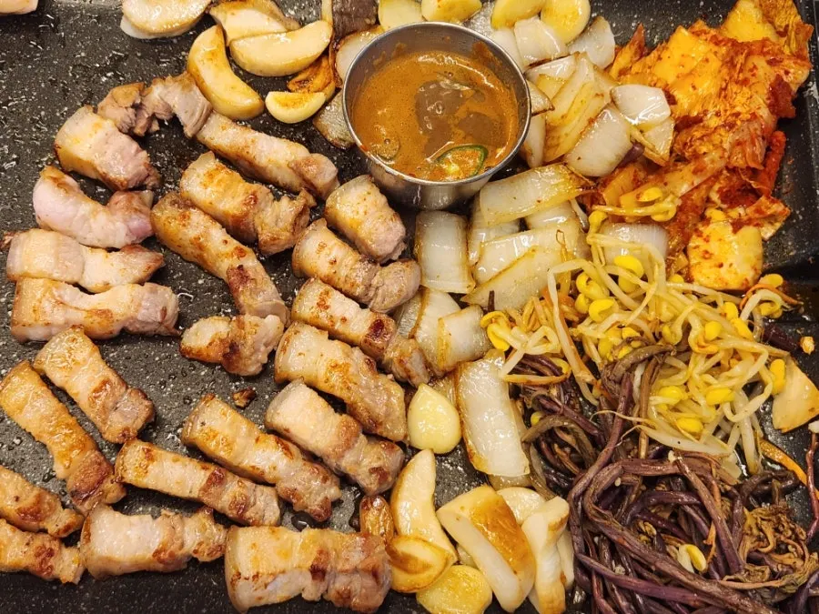 Kimchi and vegetables grilling alongside the pork belly