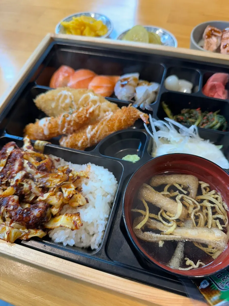 Jejju lunch box with sushi, fried items, and stir-fried octopus