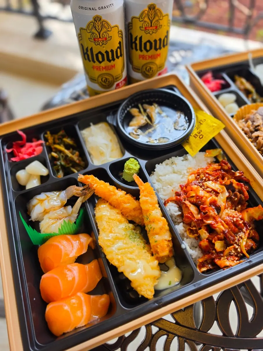 Jejju box filled with sushi, fried food, and stir-fried jjukkumi