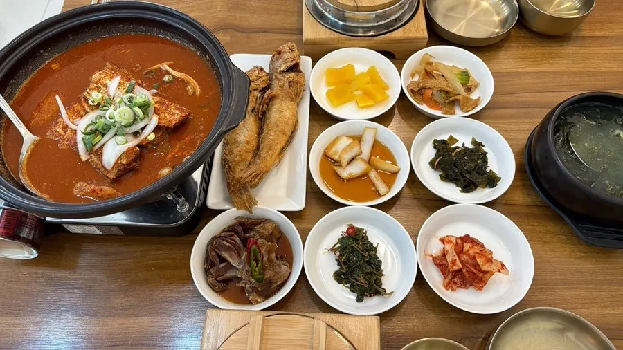 Wide shot of the braised hairtail table setting with side dishes