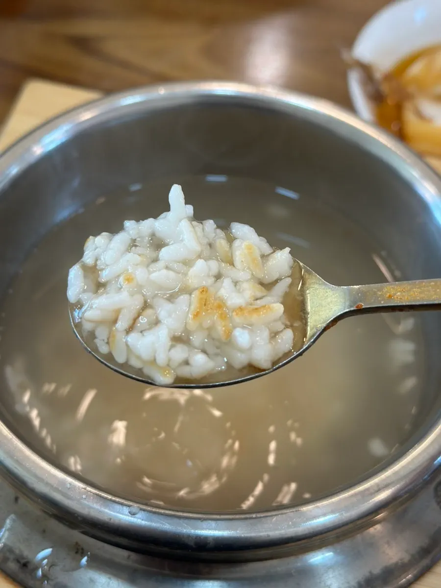 Stone pot with rice scooped out, showing scorched rice
