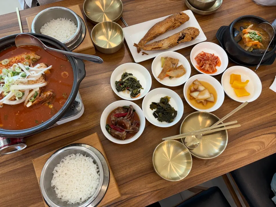 Full table setting with braised hairtail, sweet pot rice, grilled tilefish, and seafood hot pot
