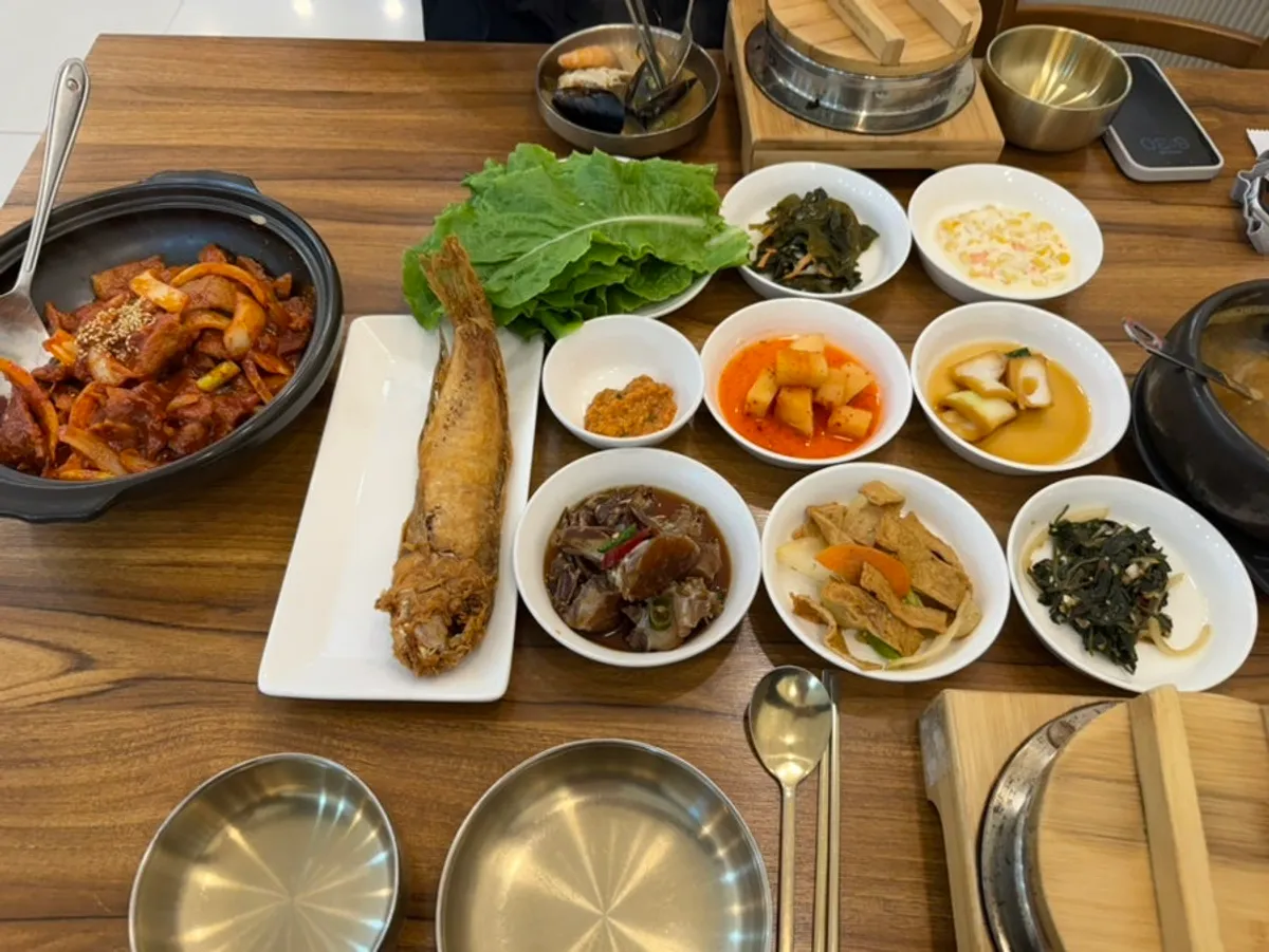 Table setting with 9 side dishes including soy-marinated crab