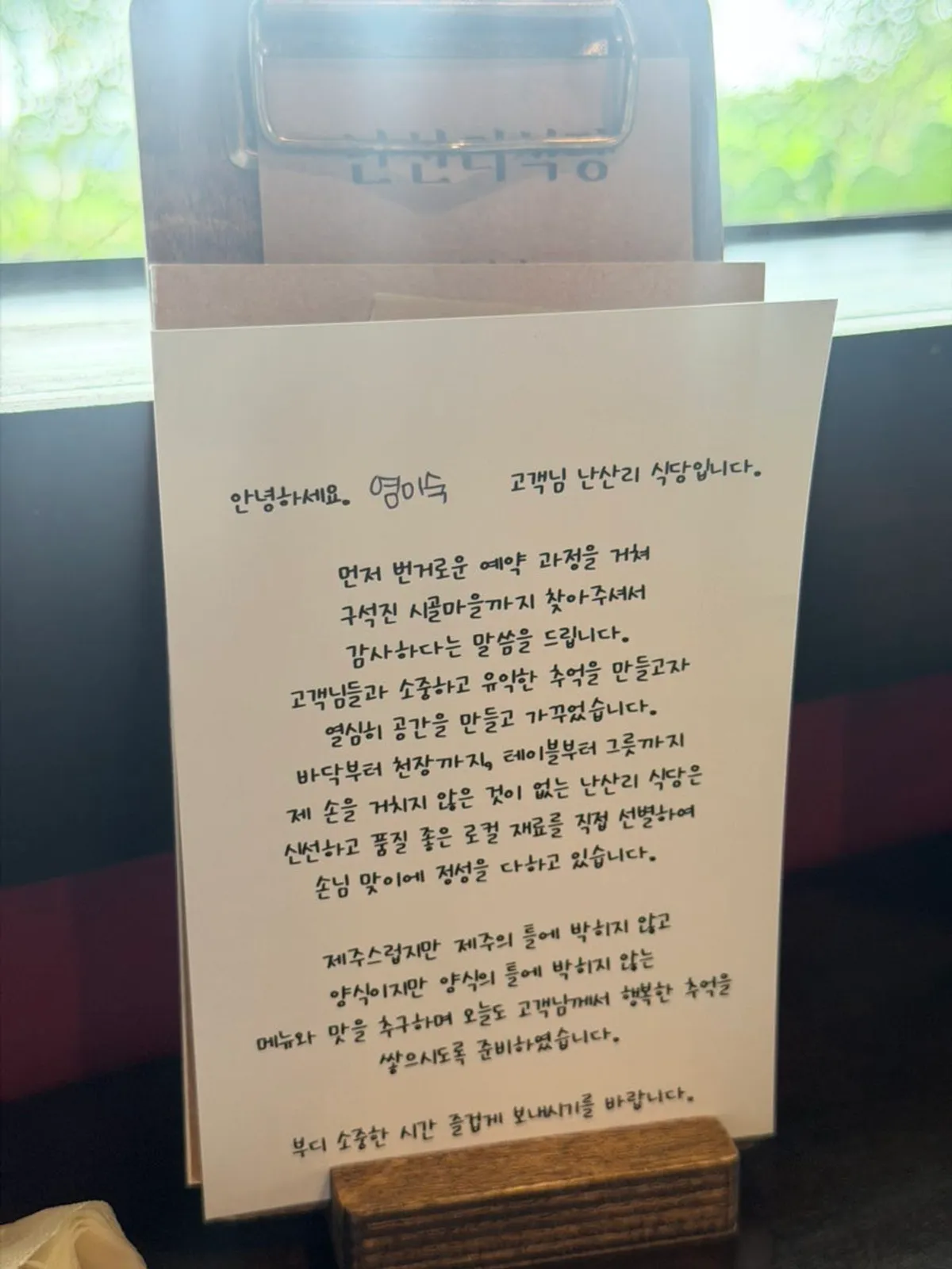 차분한 조도의 난산리식당 내부와 오픈 키친