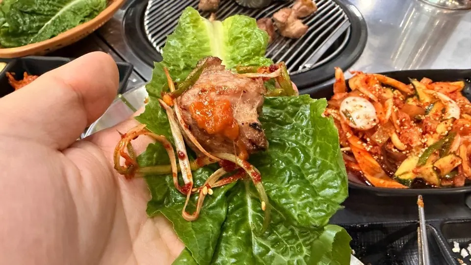 Table spread of grilled black pork with side dishes