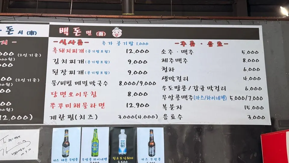 Meal menu board listing black pork stew and buckwheat noodles