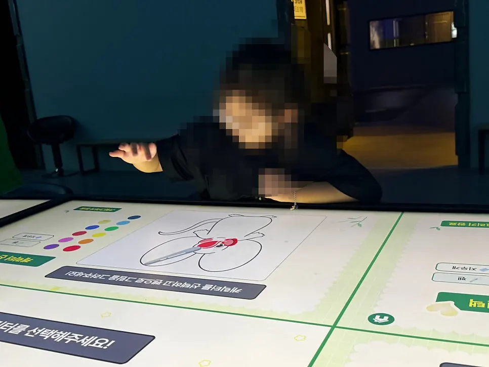 A child coloring a character on the touchscreen