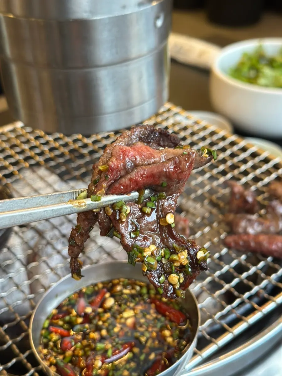 Hanwoo cooking on the grill alongside garlic