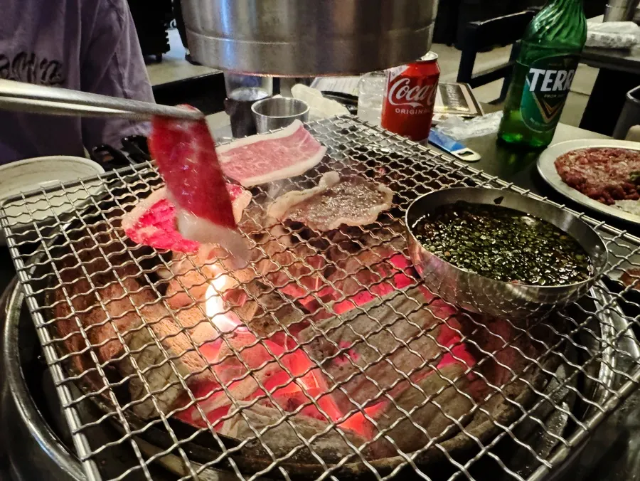 Hanwoo dipped in sauce on the grill