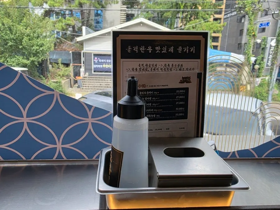메뉴판과 휴지, 불 끄기 물이 놓인 테이블