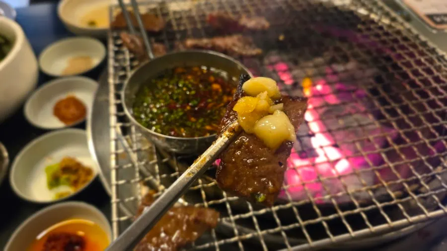 A piece of hanwoo galbisal dipped in sauce
