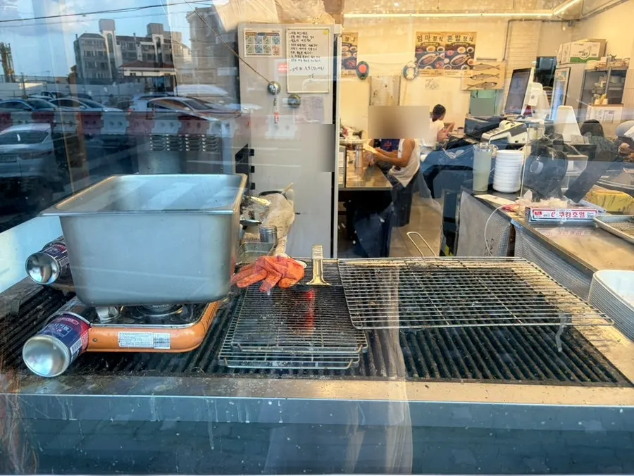 Fish being grilled in the open space outside the restaurant