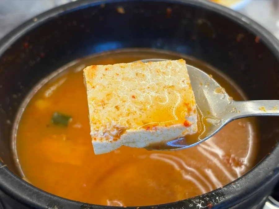 A bowl of kimchi jjigae with hearty tofu